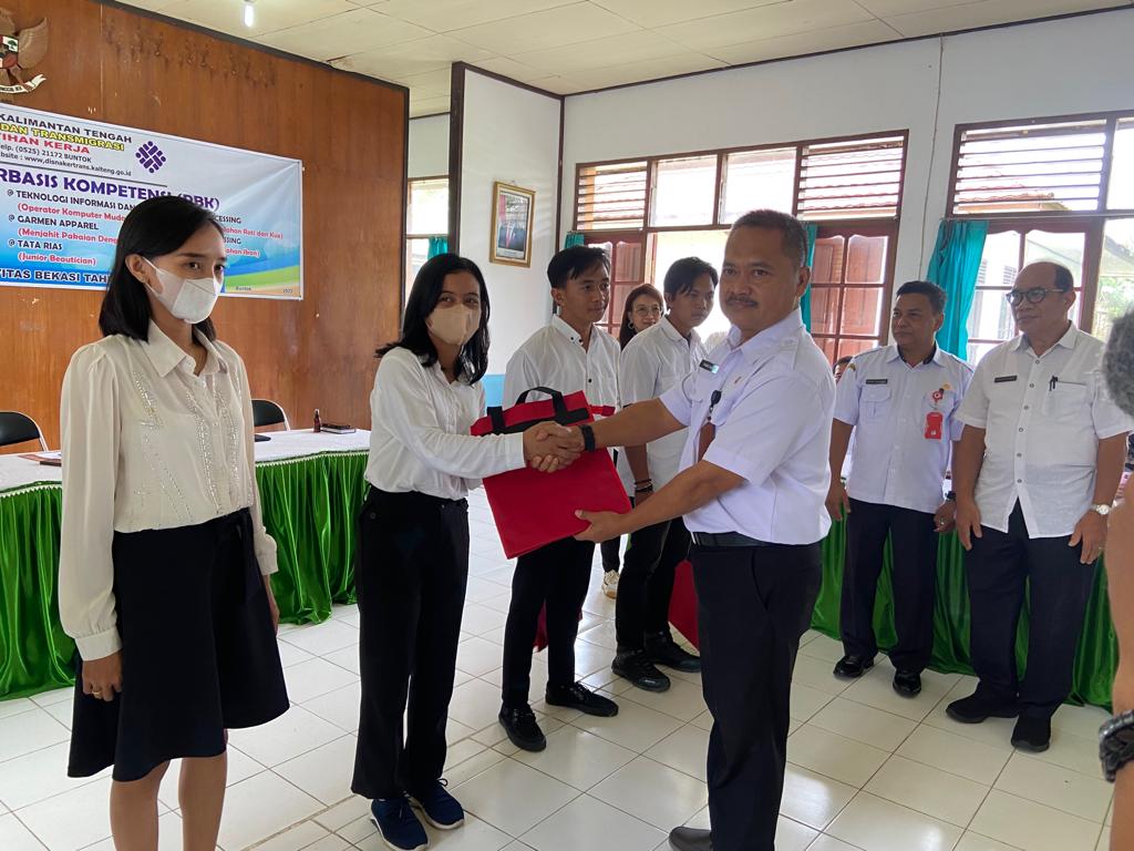 Kepala Dinas Tenaga Kerja dan Transmigrasi Prov.Kalteng Farid Wajdi saat menyerahkan tas kepada peserta. (foto/mmckalteng)